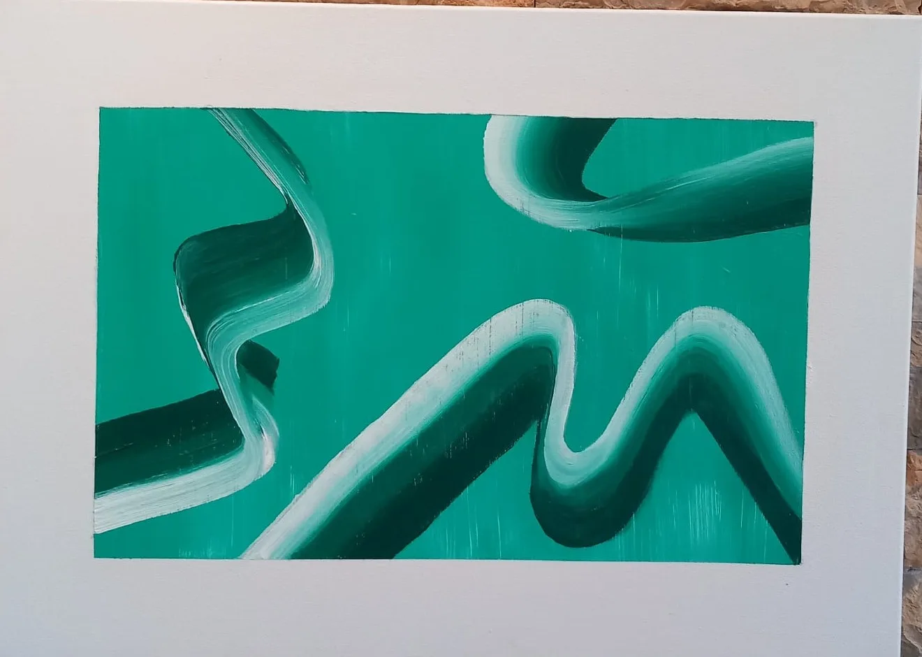 A white road winding across a green ground